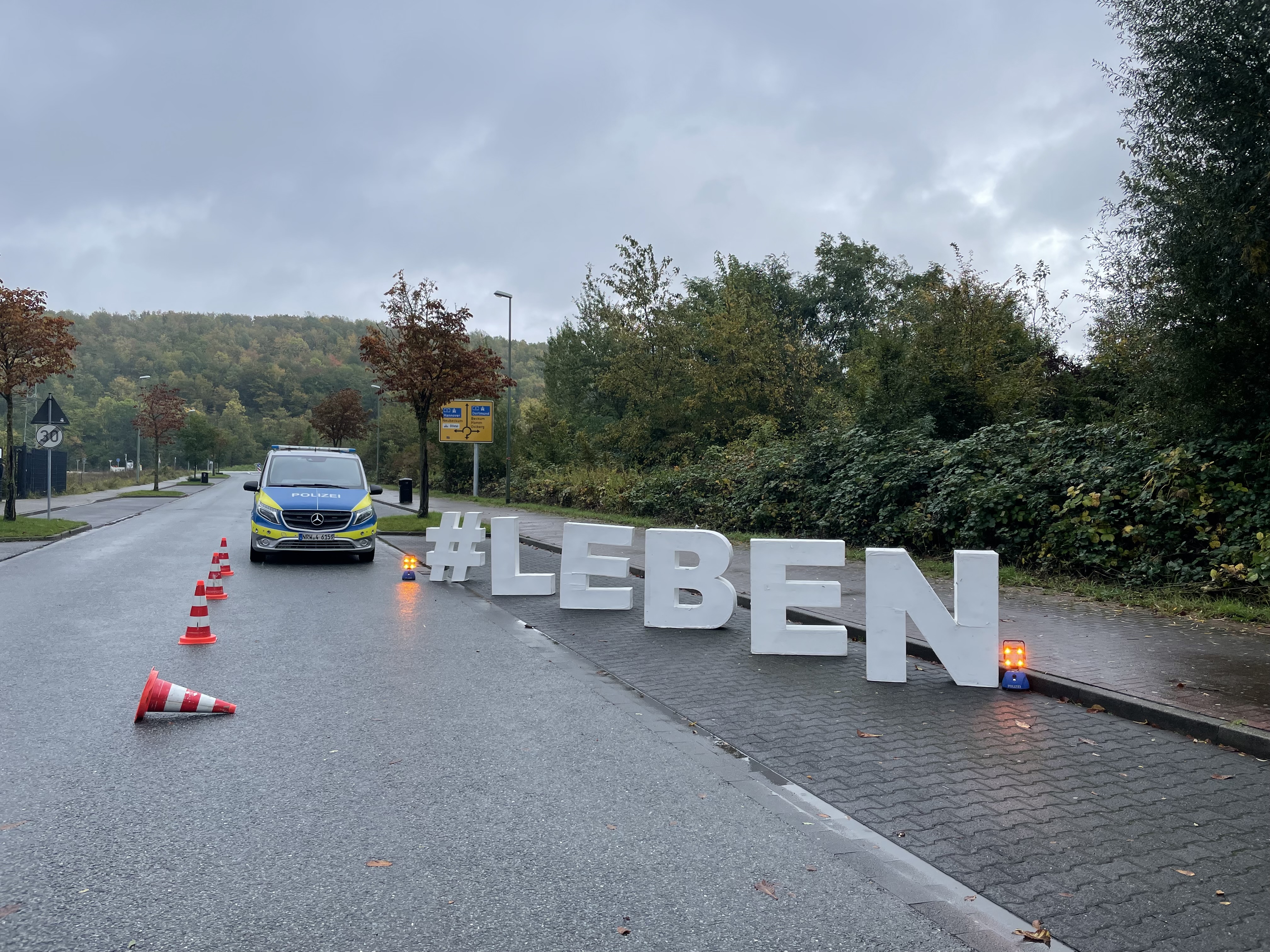 Polizeifahrzeug und große Buchstaben "#LEBEN"