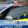 Polizist vor Polizeiauto