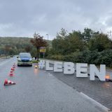 Polizeifahrzeug und große Buchstaben "#LEBEN"