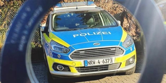 Polizeiauto umrahmt von Handschellen