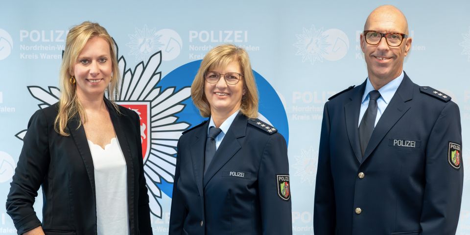 zwei Frauen und ein Mann vor blauem Hintergrund