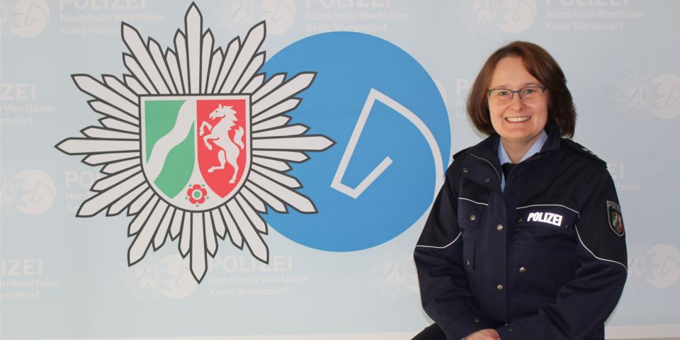 Frau in Uniform vor Logowand